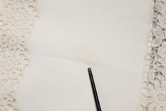 تنورة بيضاء بخصر عالٍ وقصة ضيقة من الدانتيل المزين بالزهور